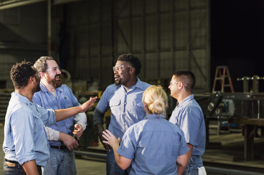 Multi-ethnic workers in warehouse having meeting