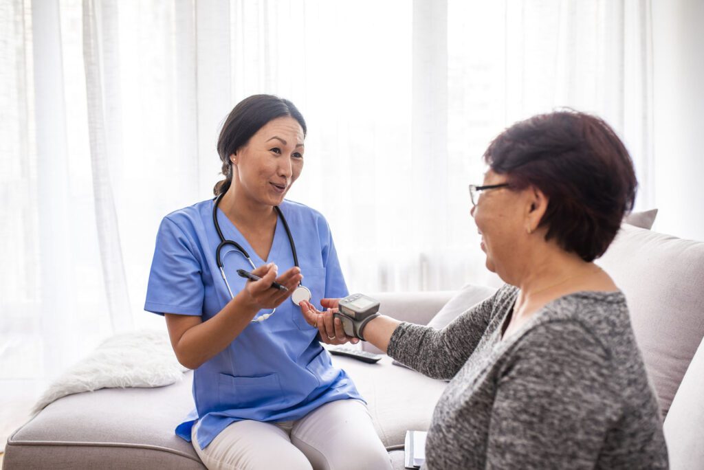 Home care nurse measuring blood pressure of senior woman