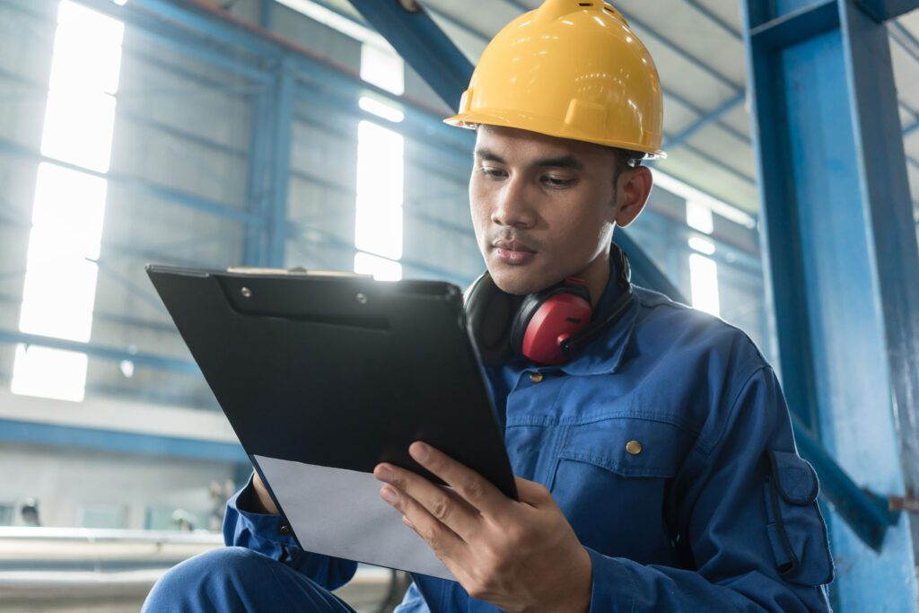 Asian worker writing observations about manufacturing