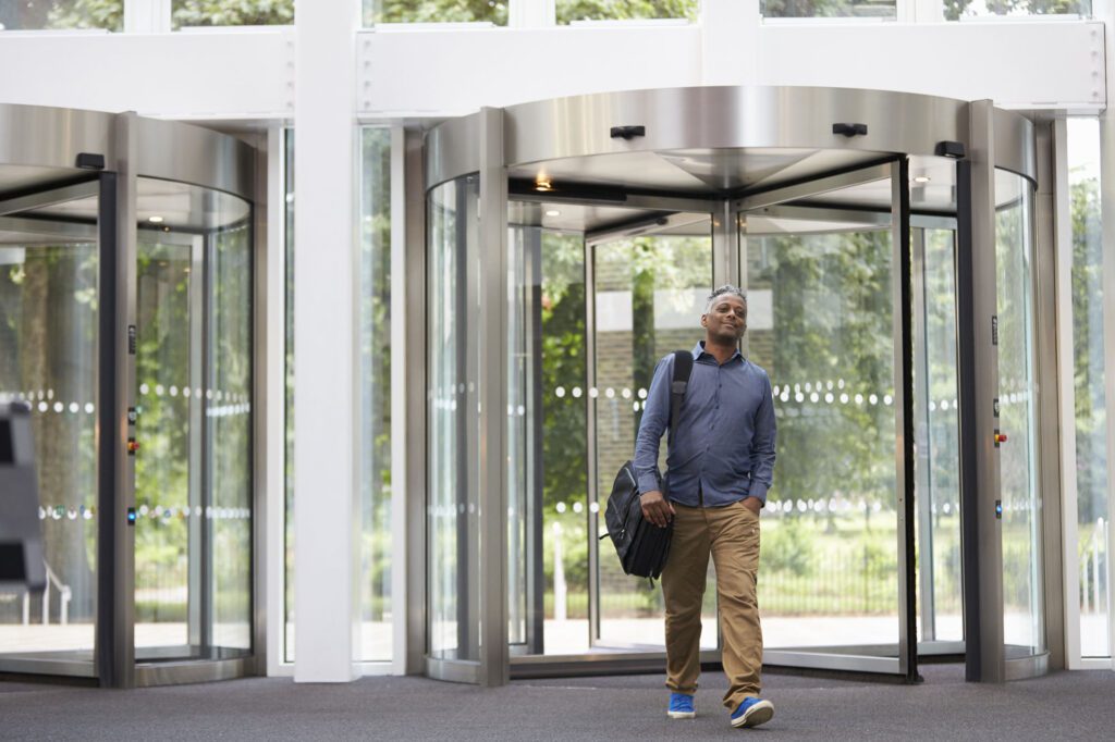 Middle aged black man entering the foyer of modern building