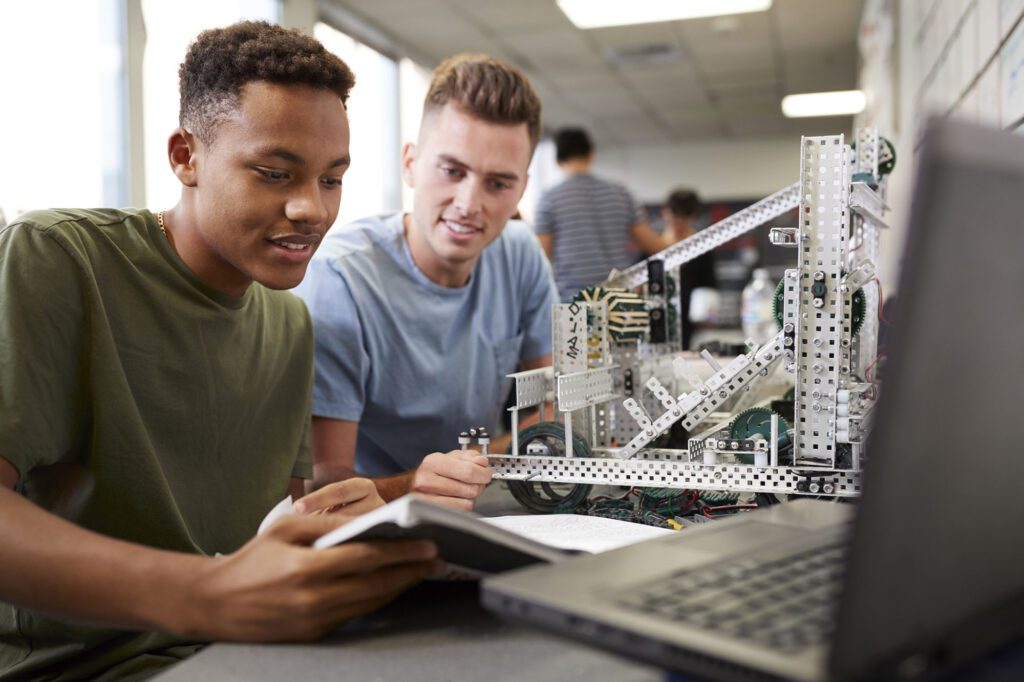 Two Male University Students Building Machine In Science Robotics Or Engineering Class