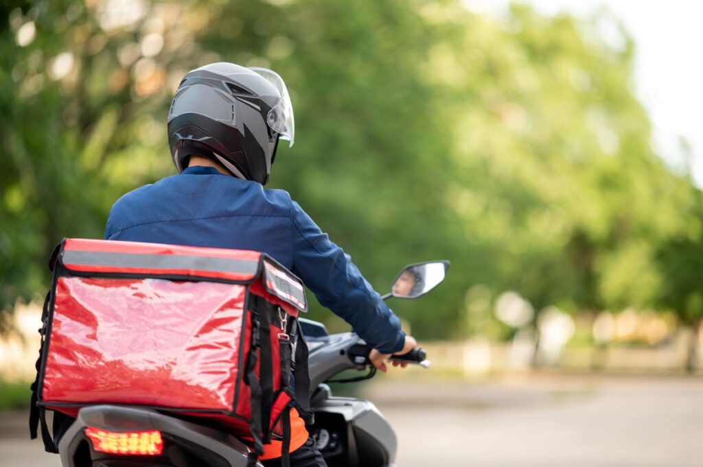 The staff prepares the delivery box on the motorcycle for delivery to customers.