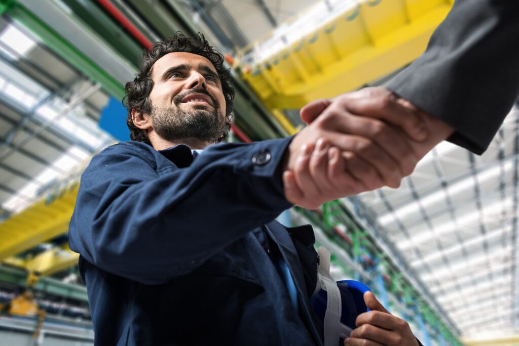 Men shaking hands in an industrial facility