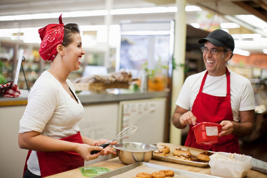 Young woman and man laughing in commercial kitchen