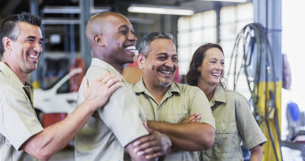 Four trucking company workers in garage