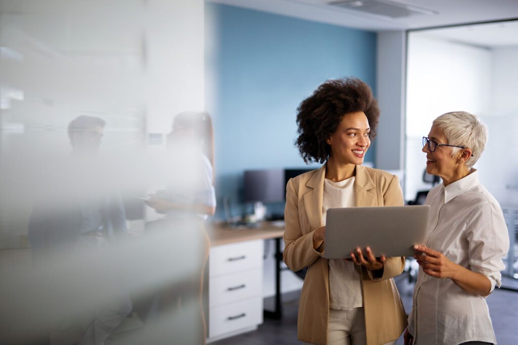 Happy multiethnic smiling business women working together in office