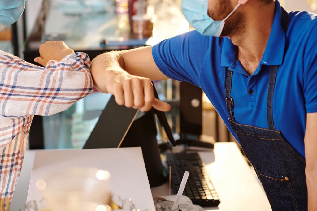 Elbow bump with coffeeshop barista