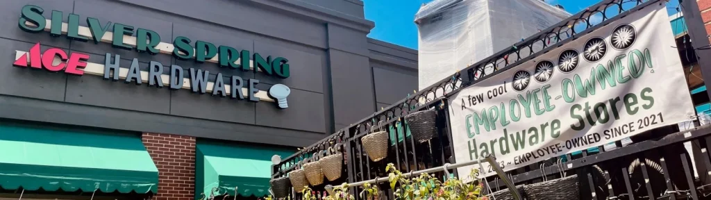 A building with a sign that reads 'Silver Spring ACE Hardware' and a banner that reads 'A few cool employee-owned hardware stores. Employee-owned since 2021.'