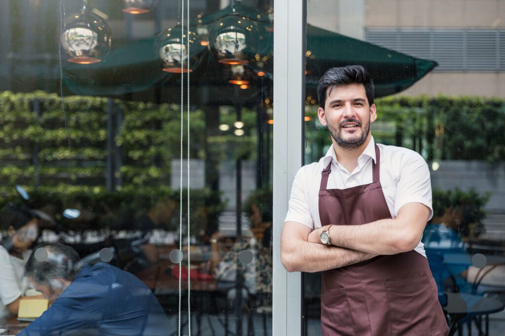 Startup successful small business owner man walking in his coffee shop or restaurant.