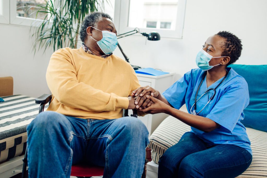 Senior man in a nursing home is being supported by his caregiver